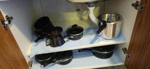 a shelf with pots and pans and a sink at Loft 3 com ar-condicionado da Rede Urbana in Indaiatuba