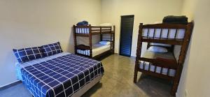 a bedroom with a bed and two bunk beds at Loft 3 com ar-condicionado da Rede Urbana in Indaiatuba