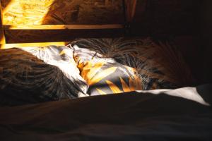an unmade bed with a comforter on it at Poscenje in Šavnik