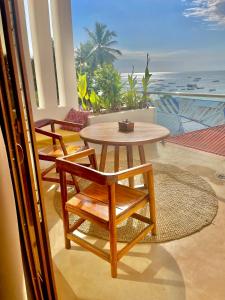 a table and chairs on a balcony with a view of the ocean at Aluna Beach Apartments in Nungwi