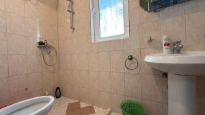 a bathroom with a sink and a toilet and a shower at Gioele apartament in Vlorë +36 photos