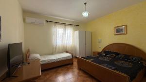 a bedroom with two beds and a television in it at Gioele apartament in Vlorë