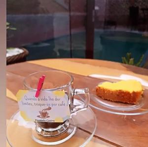 a glass mug with a piece of cake on a table at Pousada Castro in Aparecida