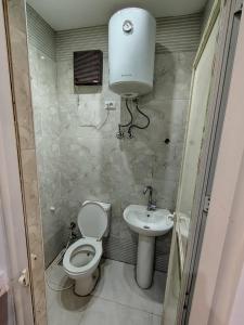 a small bathroom with a toilet and a sink at Abu safa home in Al Ghuşnah