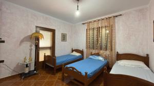 a bedroom with two beds and a window at Gioele apartament in Vlorë