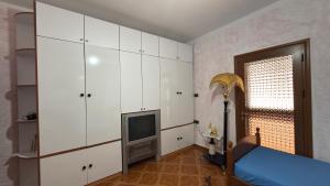 a bedroom with white cabinets and a television at Gioele apartament in Vlorë