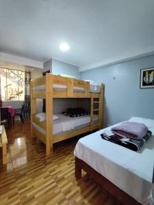 a bedroom with two bunk beds and a living room at Hotel El Sol de Carhuaz in Carhuaz