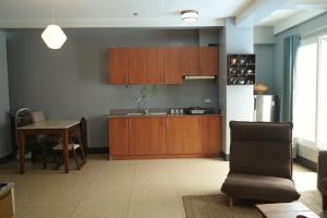 a kitchen with wooden cabinets and a table and a chair at Apartment with Kitchen Walking Distance to Station Two in Boracay