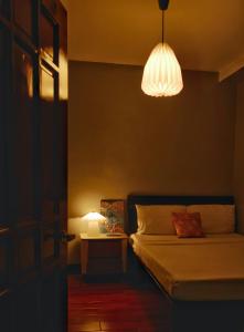 a bedroom with a bed with a lamp and a table at Apartment with Kitchen Walking Distance to Station Two in Boracay +10 photos