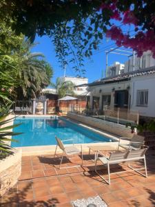 a swimming pool with two lounge chairs next to a house at VILLA San Juan PLAYA Alicante in El Campello