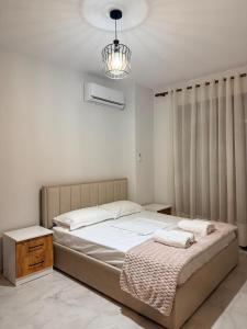 a bedroom with a bed and a chandelier at Coastal Pine Appartment in Golem
