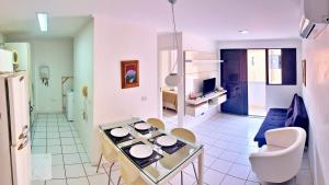 a kitchen and living room with a table with plates on it at Vacanze - Neo in Maceió