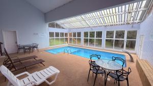 a swimming pool with a table and chairs and a tableasteryasteryasteryasteryastery at Hotel Renascença By Rede Elevare in Gramado