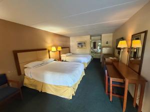 a hotel room with two beds and a desk at Camilla Inn & Suites in Camilla