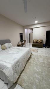 a bedroom with a large bed and a couch at Cozy rooms in Mirbāţ