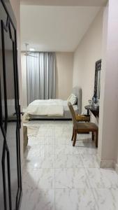 a bedroom with a bed and a desk and a chair at Cozy rooms in Mirbāţ