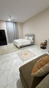a large room with two beds and a television at Cozy rooms in Mirbāţ