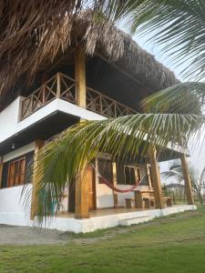 a house with a hammock in front of it at Karpatty Mar Cabañas in San Bernardo del Viento