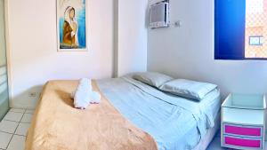 a room with a bed with a teddy bear on a blanket at Vacanze - Neo in Maceió +22 photos