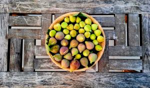 a bowl of fruit sitting on a wooden table at Dreaming Polignano in San Vito