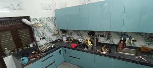 a kitchen with blue cabinets and a sink at Vallabh Kunj Sewa Sadan in Govardhan
