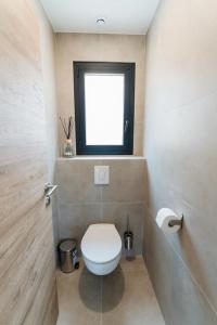 a bathroom with a white toilet and a window at Villa Ezilia in Alata +6 photos