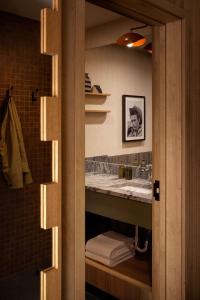 ein Badezimmer mit Waschbecken und Spiegel in der Unterkunft The Kenrick Hotel in Banff + 47 Fotos