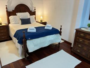 a bedroom with a bed with two towels on it at Geninha Stay Aveiro in Aveiro