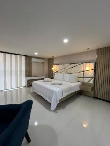 a bedroom with a large white bed and a couch at Euros Hotel in El Bordo
