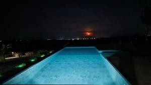 a swimming pool at night with the moon in the background at Dreaming Polignano in San Vito