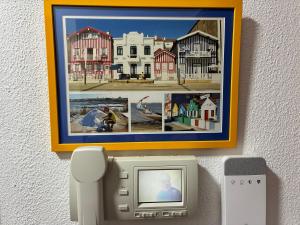 a wall with a picture of a town and a phone at Geninha Stay Aveiro in Aveiro