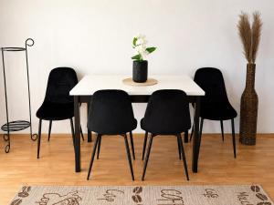 a table with black chairs and a vase with flowers on it at Gunilak in Dombóvár