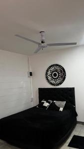 a bedroom with a black bed with a ceiling fan at 3 Acogedor y confortable monoambiente in Santiago del Estero
