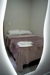 a bed with a purple blanket and a white towel on it at Casa 2 Quartos com Ar até 8 Pessoas Jd. Sabiás in Indaiatuba