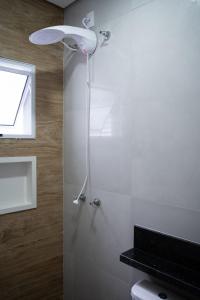 a bathroom with a shower with a toilet and a window at Casa 2 Quartos com Ar até 8 Pessoas Jd. Sabiás in Indaiatuba