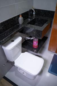 a bathroom with a white toilet and a sink at Casa 2 Quartos com Ar até 8 Pessoas Jd. Sabiás in Indaiatuba +40 photos