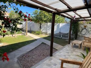 a patio under a pergola with a picnic table and benches at 3 Acogedor y confortable monoambiente in Santiago del Estero