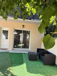 a house with a lawn with two chairs on it at NovaStay in Breuillet