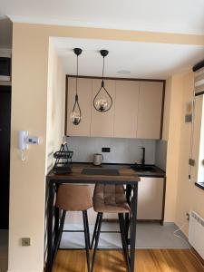 a kitchen with a table and two lights at Amara in Zlatibor