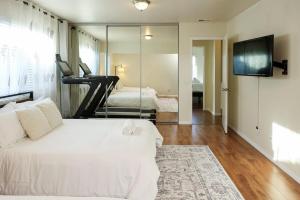 a bedroom with a white bed and a mirror at The Mira Mesa Gamezone in San Diego