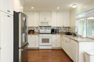a kitchen with white cabinets and stainless steel appliances at The Mira Mesa Gamezone in San Diego