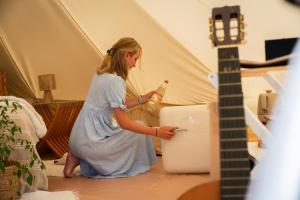 a woman standing next to a guitar in a tent at Glamping Ty Západy in Stanový