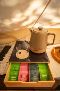 a tray of books with a tea kettle on top at Glamping Ty Západy in Stanový