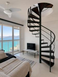 a spiral staircase in a bedroom with a view of the ocean at Porto Real Resort Suítes in Mangaratiba