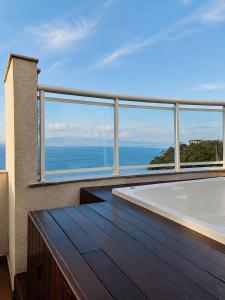a balcony with a tub and a view of the ocean at Porto Real Resort Suítes in Mangaratiba
