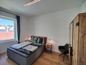 a bedroom with a bed and a large window at Apartment Felicitas FEE in Tulln