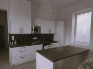 a kitchen with white cabinets and a black counter top at Apartment Felicitas FEE in Tulln