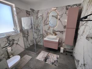 a bathroom with a toilet and a sink and a mirror at Apartment Felicitas FEE in Tulln +7 photos