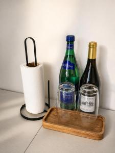 two bottles of wine and a glass on a cutting board at Waterford Triangle Apartment in Waterford +8 photos