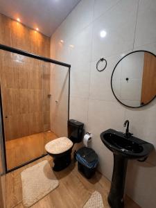 a bathroom with a shower and a sink and a mirror at Recanto Paraiso Tropical- Praia Ajuruteua in Bragança